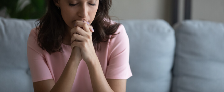 stressed woman sitting on the couch alone