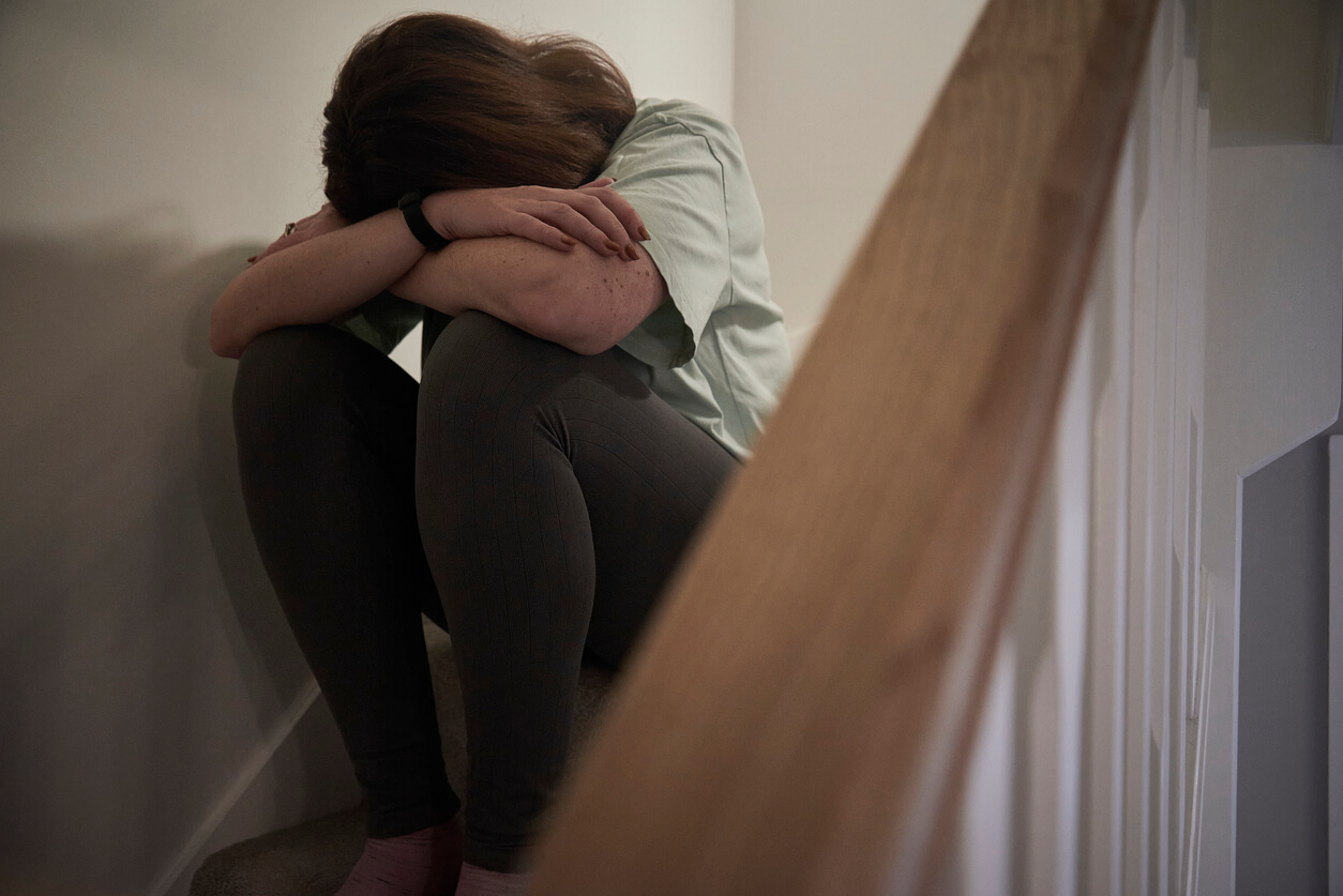 victim of domestic violence crying on stairs