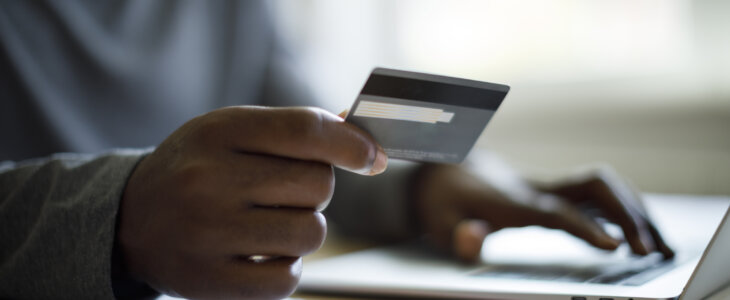 Man using credit card and laptop for online shopping