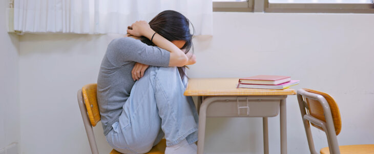 Female student is crying and depressed in classroom